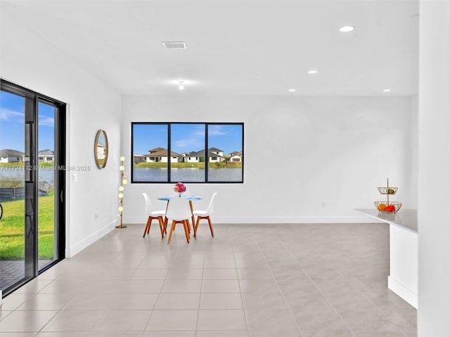 tiled dining space with a water view