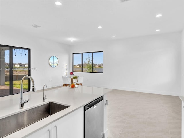 kitchen featuring sink, white cabinetry, light tile patterned floors, and dishwasher