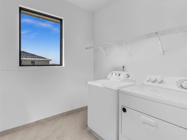 clothes washing area featuring light tile patterned floors and independent washer and dryer