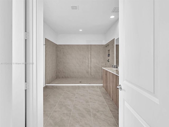 bathroom with vanity, tile patterned floors, and a tile shower