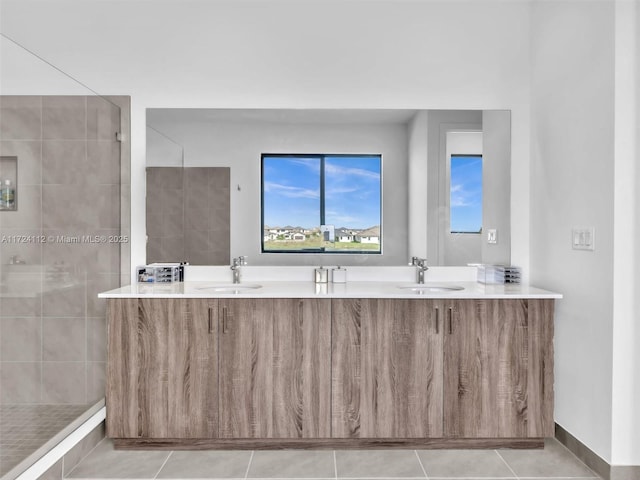 bathroom featuring vanity, a tile shower, and tile patterned flooring