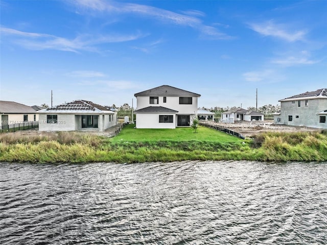 back of property featuring a water view and a yard