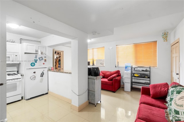 kitchen featuring stone countertops, white cabinetry, and white appliances