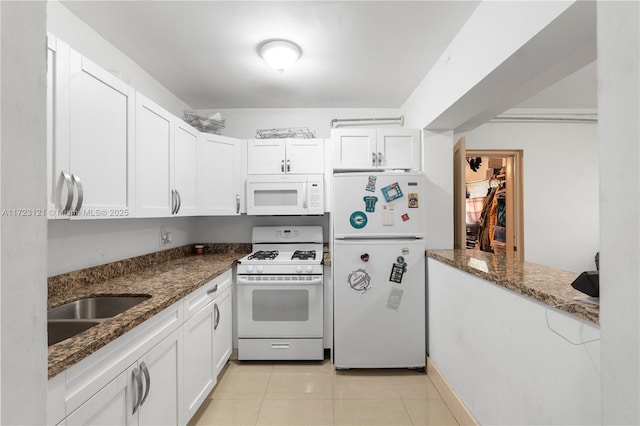 kitchen with dark stone countertops, white cabinets, and white appliances