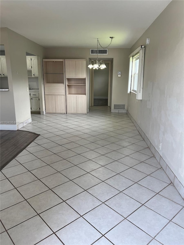 unfurnished living room with light tile patterned floors and an inviting chandelier