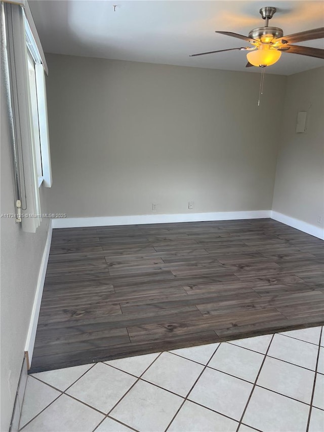 tiled spare room with ceiling fan