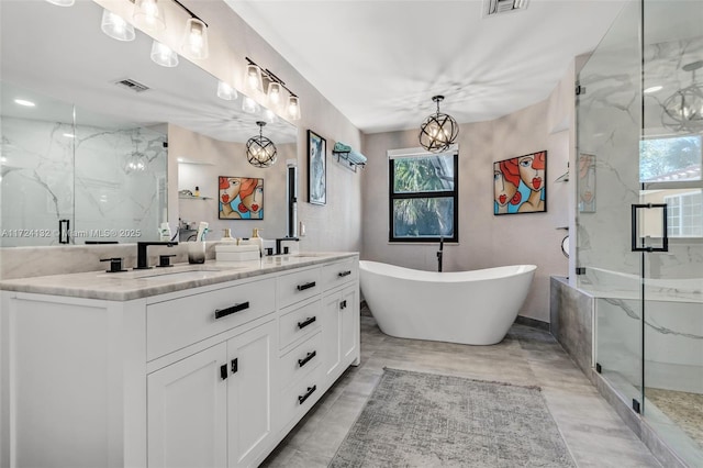 bathroom featuring vanity, a notable chandelier, and shower with separate bathtub