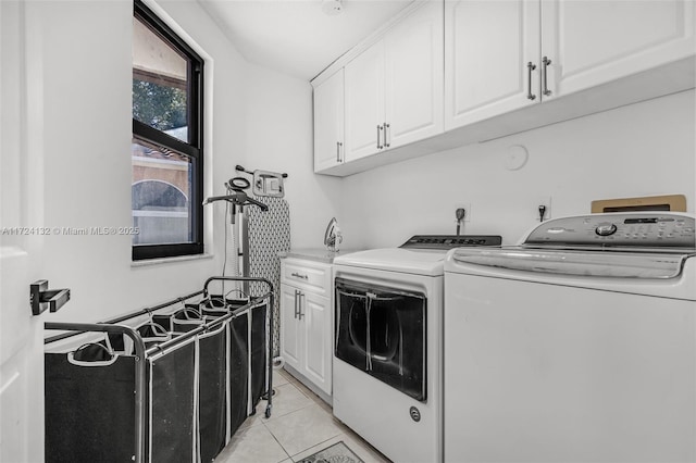 clothes washing area with cabinets, independent washer and dryer, and light tile patterned floors