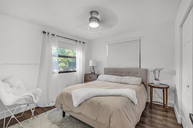 bedroom featuring ceiling fan, dark hardwood / wood-style flooring, and a closet