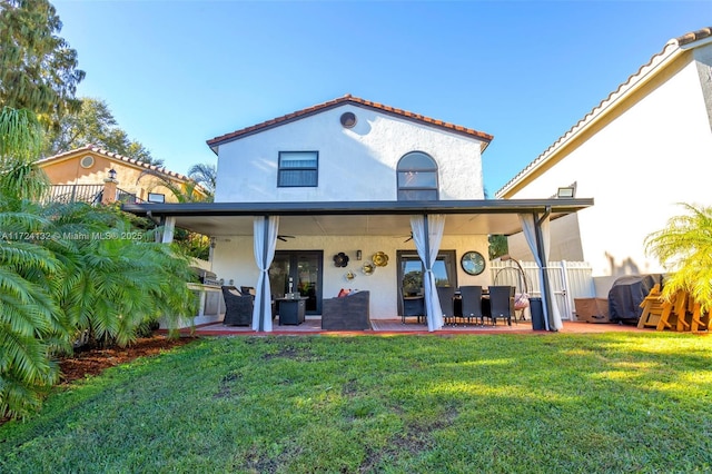 rear view of house with a yard and a patio area