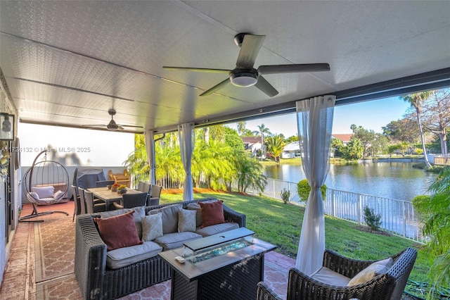 view of patio / terrace featuring a water view and an outdoor living space with a fire pit