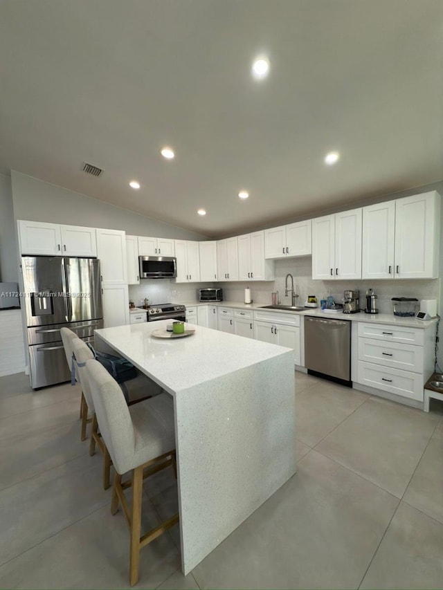 kitchen featuring appliances with stainless steel finishes, white cabinetry, and sink