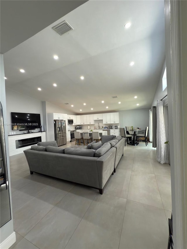 living room with a fireplace and lofted ceiling