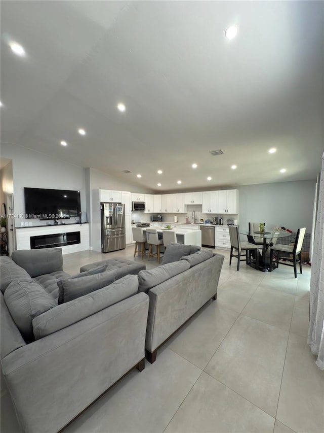 living room featuring sink and vaulted ceiling