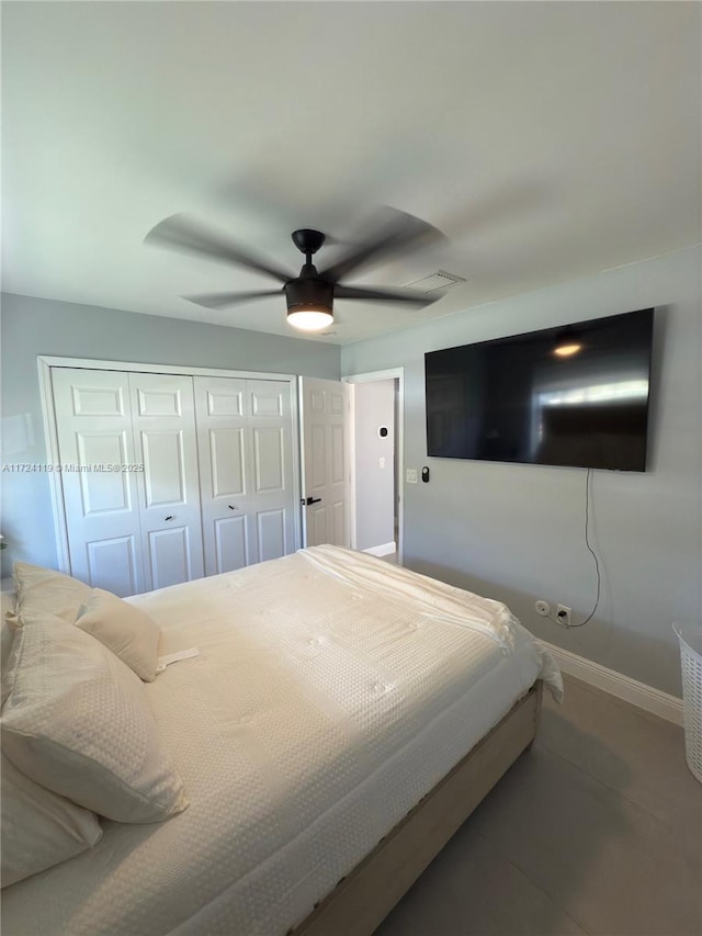 tiled bedroom featuring ceiling fan and a closet