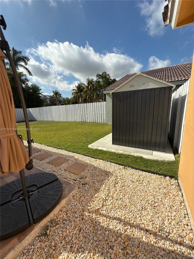 view of yard with a storage shed and a patio area