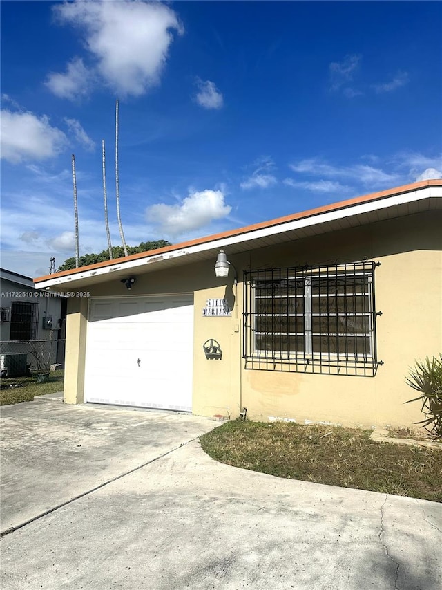 view of front of home with a garage and central air condition unit