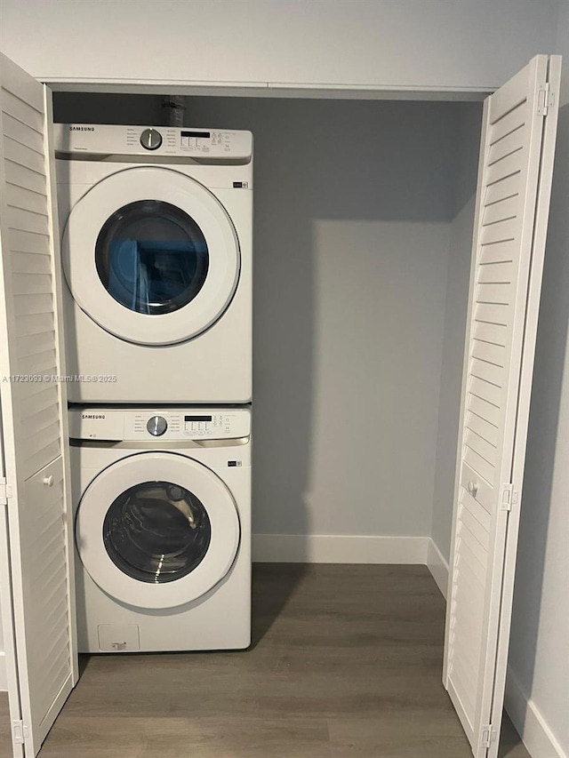 washroom featuring stacked washer and dryer and dark hardwood / wood-style floors