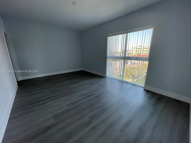 unfurnished room featuring dark wood-type flooring