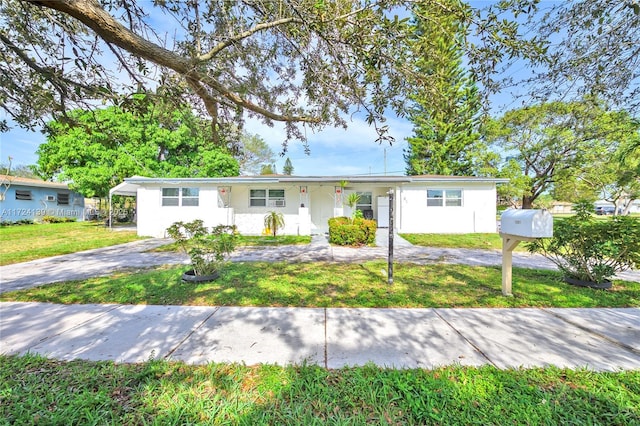 single story home with a front lawn and a carport