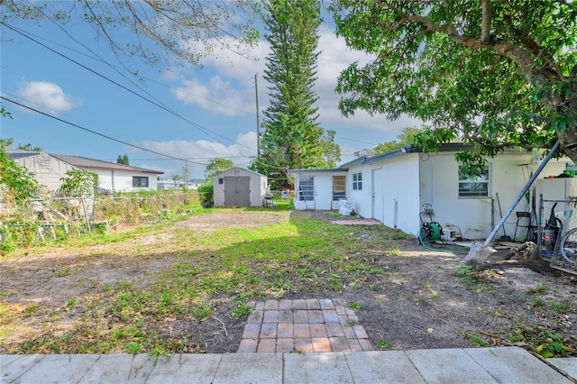 view of yard featuring an outdoor structure, fence, and a shed