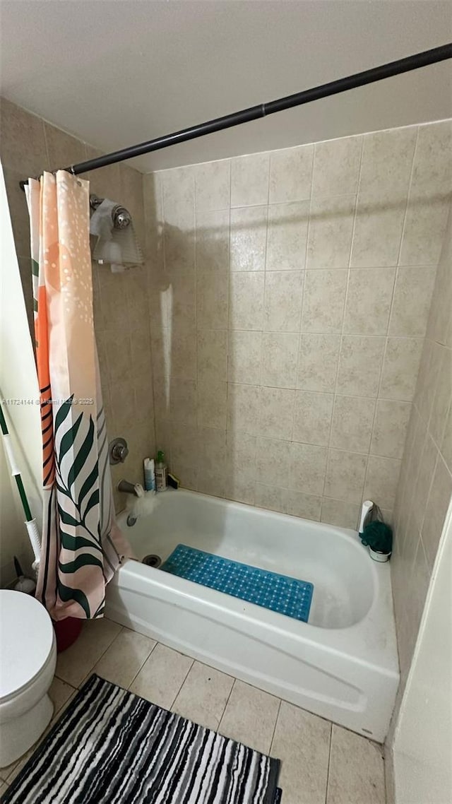 bathroom with toilet, tile patterned floors, and shower / bath combo with shower curtain