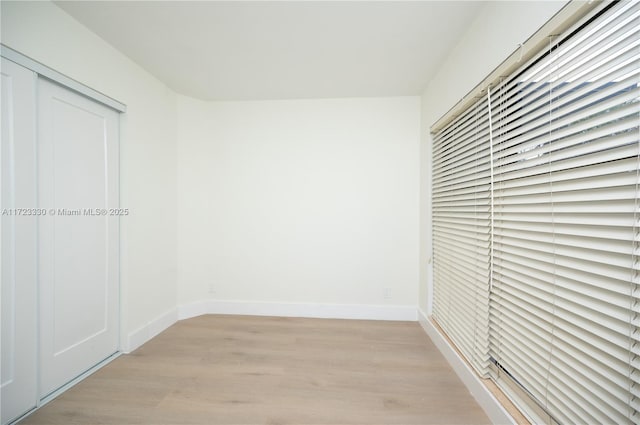 unfurnished bedroom featuring light hardwood / wood-style flooring and a closet