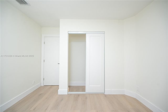 unfurnished bedroom with a closet and light hardwood / wood-style flooring