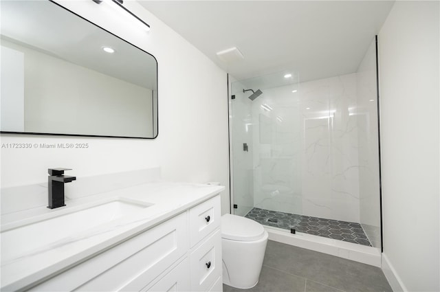 bathroom featuring a tile shower, vanity, and toilet