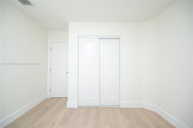 unfurnished bedroom featuring a closet and light hardwood / wood-style floors