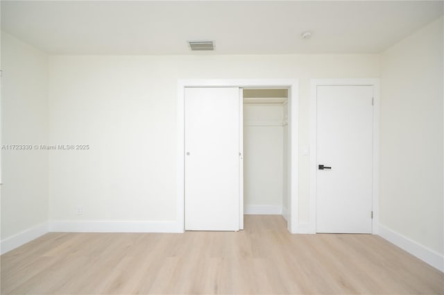 unfurnished bedroom featuring a closet and light wood-type flooring