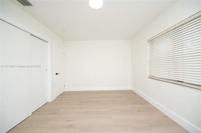 unfurnished bedroom featuring light hardwood / wood-style flooring and a closet