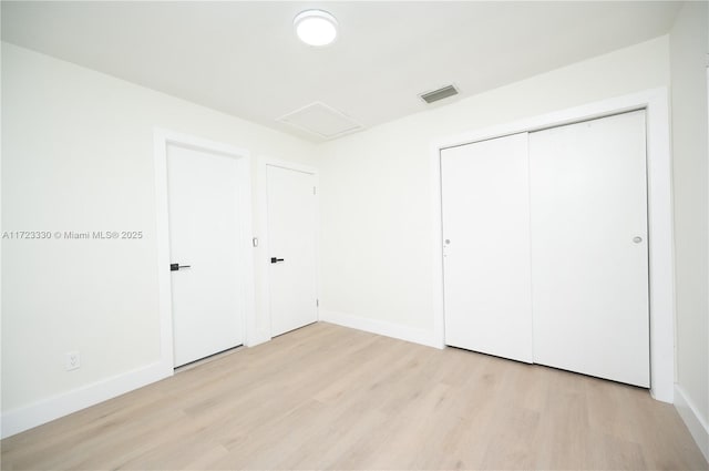 unfurnished bedroom featuring light hardwood / wood-style floors and a closet