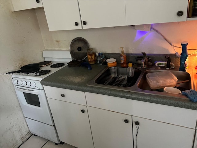 kitchen with white range, white cabinetry, sink, and light tile patterned floors