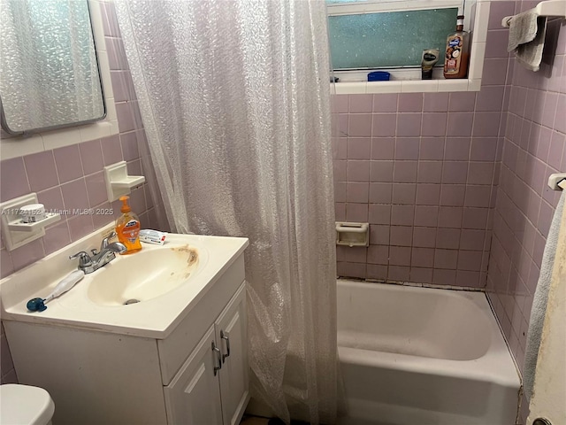 full bathroom featuring backsplash, toilet, shower / bath combo with shower curtain, vanity, and tile walls