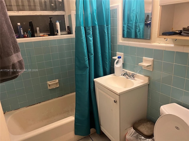 full bathroom with vanity, shower / tub combo, tile walls, and toilet