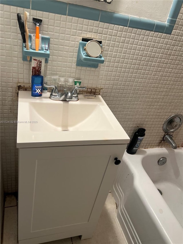 bathroom with decorative backsplash, tile patterned floors, vanity, tile walls, and a bathing tub