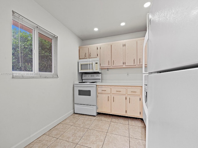 kitchen featuring light tile patterned floors, light brown cabinetry, and white appliances