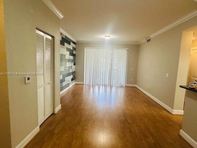 unfurnished living room with hardwood / wood-style floors and ornamental molding