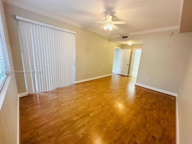 spare room with hardwood / wood-style floors, ceiling fan, and ornamental molding