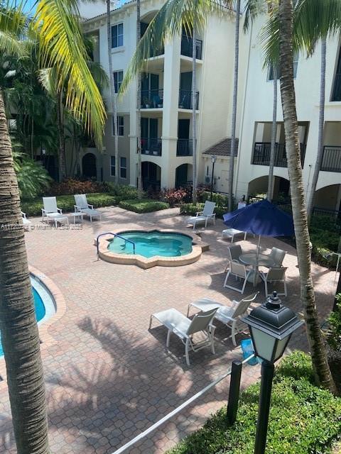 view of swimming pool featuring a hot tub and a patio area