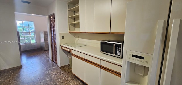 kitchen with white cabinetry, white fridge with ice dispenser, and built in desk