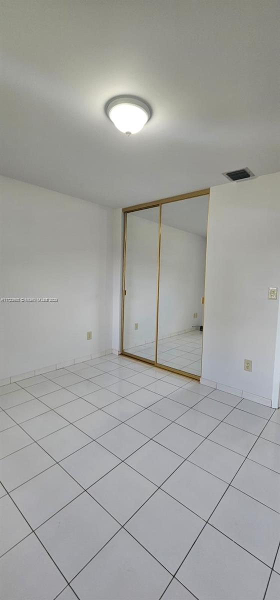 bathroom featuring vanity, an enclosed shower, tile patterned flooring, and toilet