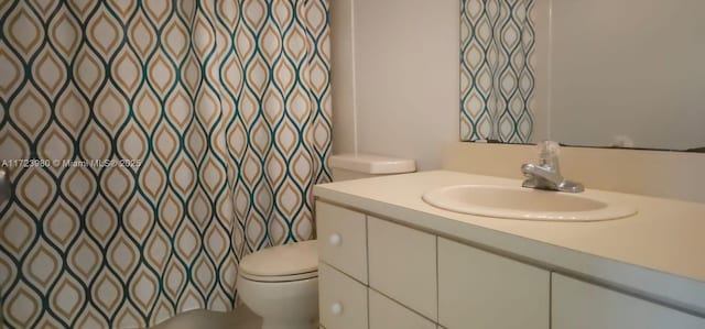 bathroom featuring vanity, toilet, and a shower with shower curtain