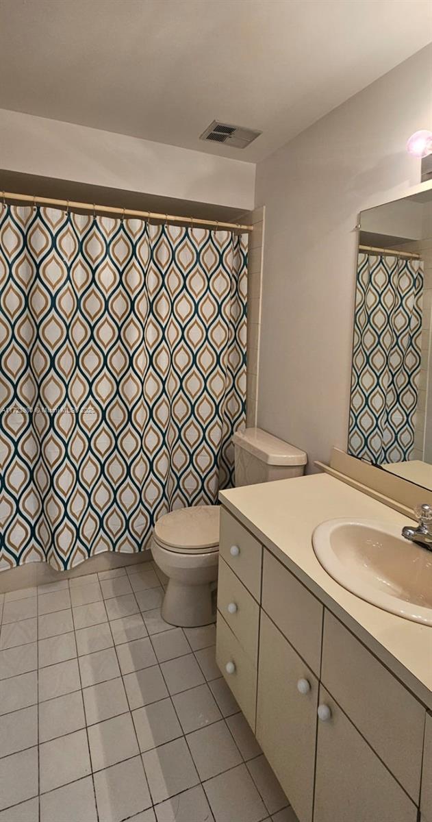 bathroom with vanity, curtained shower, and toilet