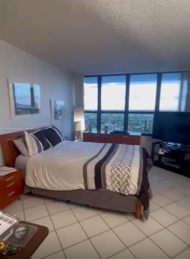 tiled bedroom featuring a textured ceiling and multiple windows