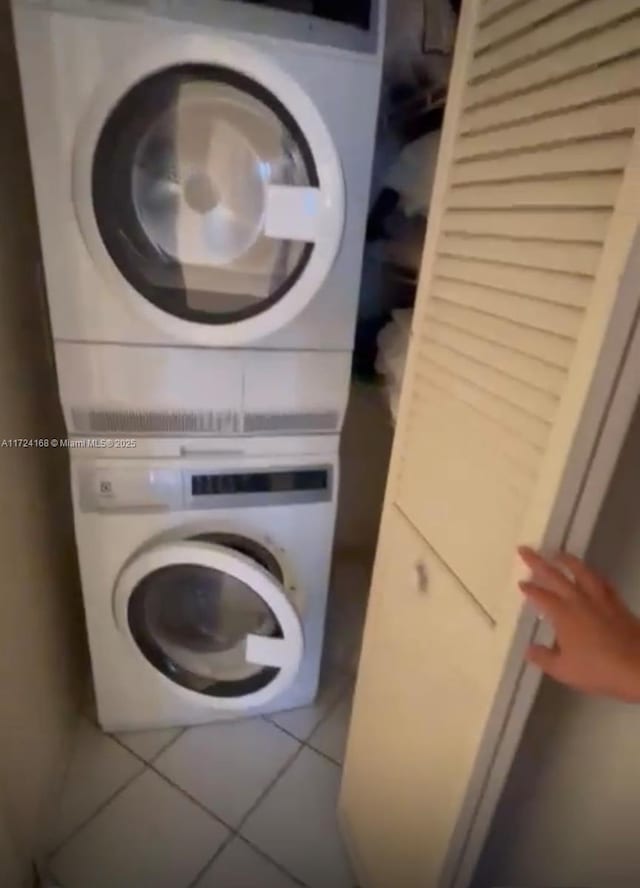 washroom with tile patterned floors and stacked washer / dryer