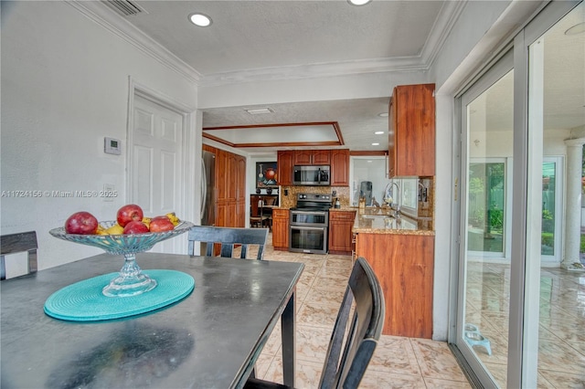 tiled dining room with ornamental molding and sink