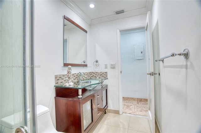 bathroom featuring tasteful backsplash, tile patterned floors, ornamental molding, vanity, and toilet