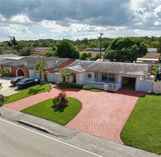 ranch-style house with covered porch, a garage, and a front yard